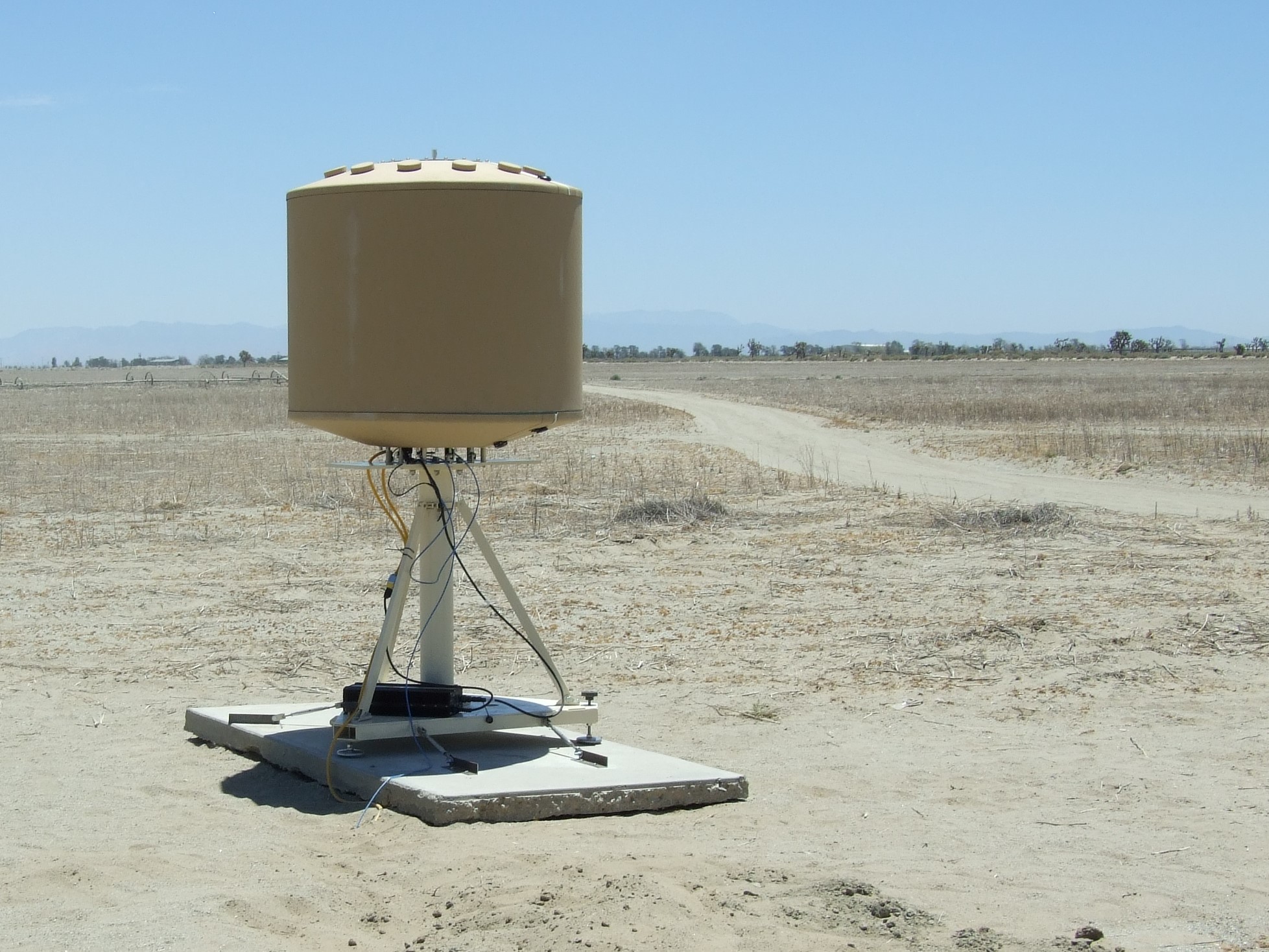 SRC's AN/TPQ-49 radar with LSTAR software in a rugged tan enclosure in front of a rugged desert landscape